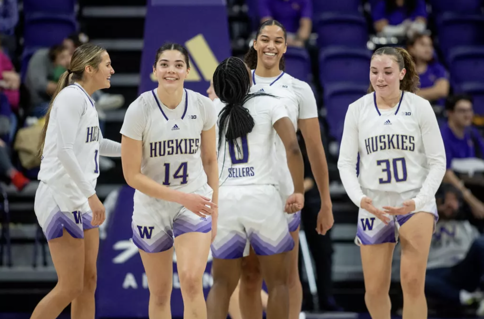 University of Washington players celebrate as they walk back to the bench against Wisconsin on January 7, 2025 at Alaska Airlines Arena in Seattle, Wash.